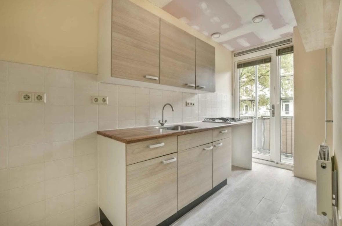 Cocina lineal en madera clara con salida a una terraza
