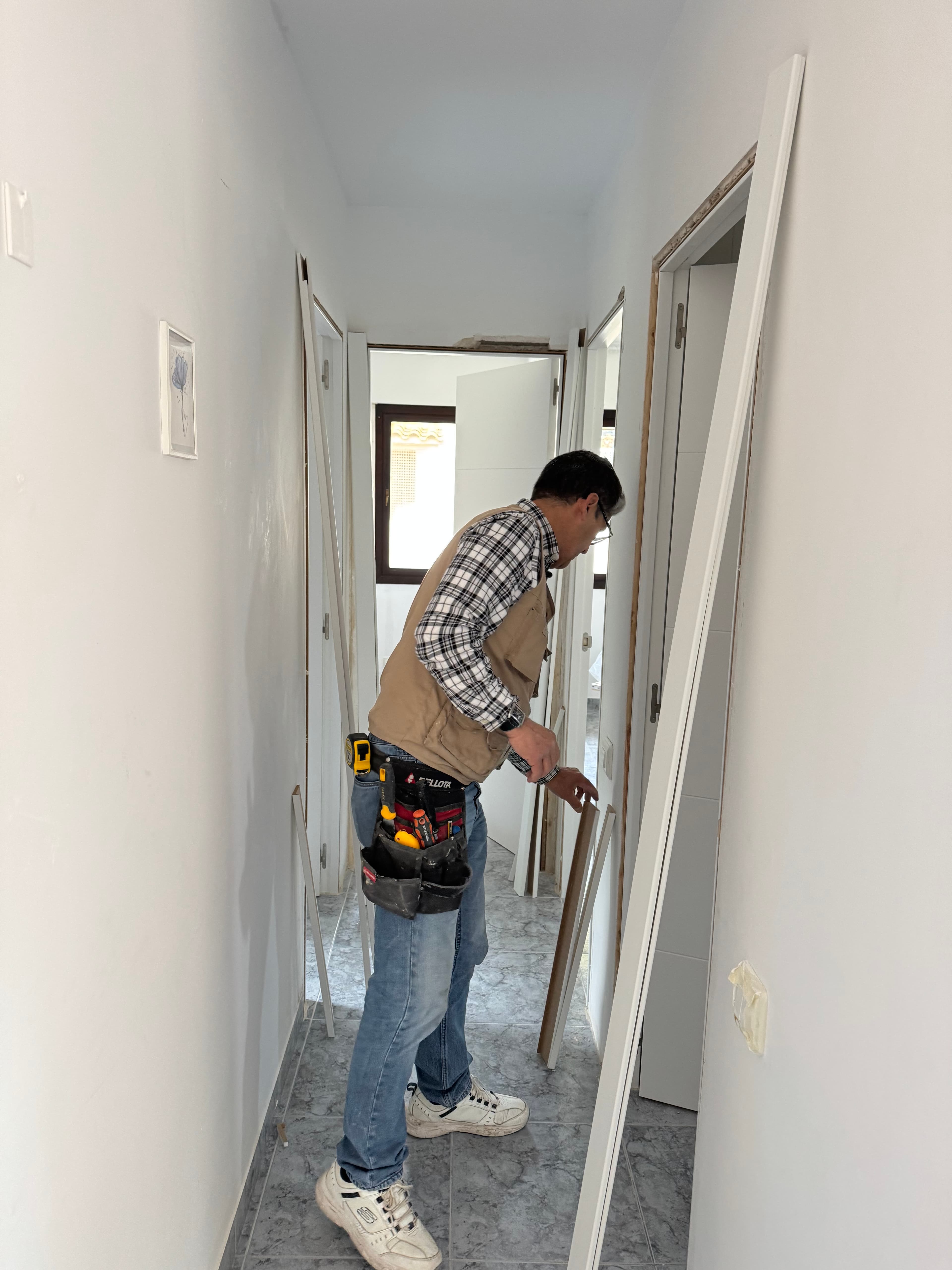 Carpintero instalando puertas blancas en una vivienda