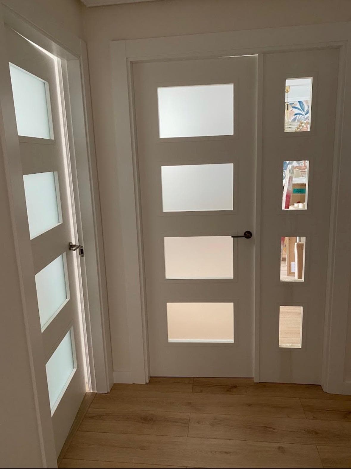 Conjunto de puertas blancas con paneles de vidrio